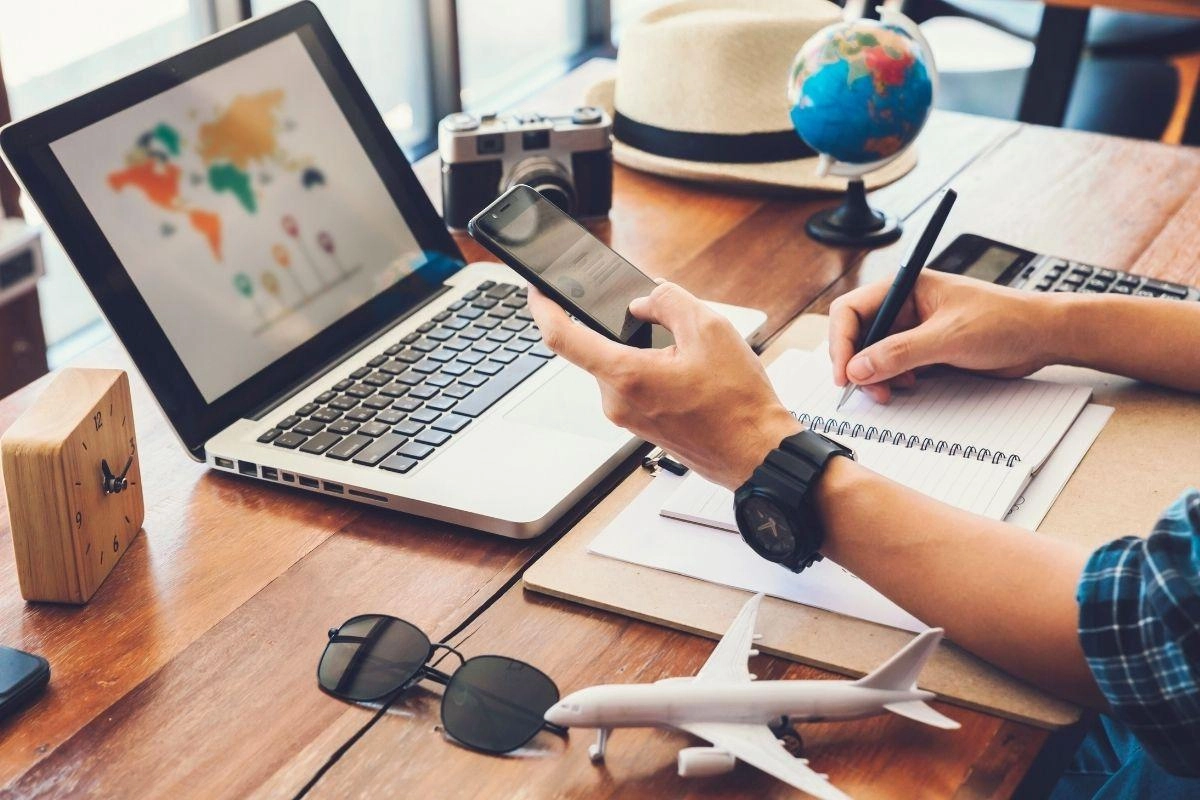 Modern travel planning using digital devices and maps.